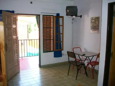 a dining room with a table and chairs and a television at Hosteria Columbia in Mina Clavero