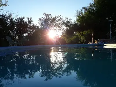 a reflection of the sun in a swimming pool at Pasos Cortos Cabañas Nono in Nono