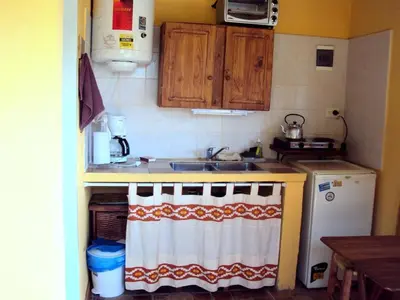 a small kitchen with a sink and a refrigerator at Pasos Cortos Cabañas Nono in Nono