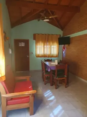a living room with a table and chairs at El Aguaribay de los Nonos in Mina Clavero