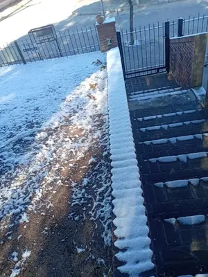 a fence with snow on the ground next to a building at El Aguaribay de los Nonos in Mina Clavero