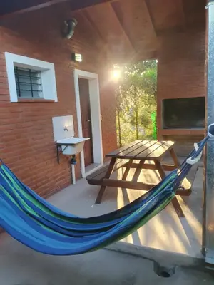 a hammock and a picnic table on a patio at El Aguaribay de los Nonos in Mina Clavero