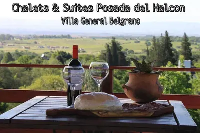 a table with a bottle of wine and a glass at Posada del Halcón - Cabañas y Suites in Villa General Belgrano