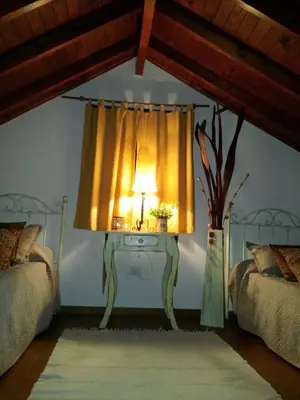 a bedroom with a table with a lamp and a window at Posada del Halcón - Cabañas y Suites in Villa General Belgrano