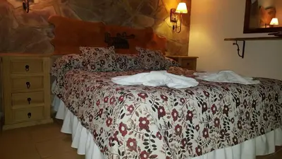 a bed in a hotel room with two towels on it at Posada del Halcón - Cabañas y Suites in Villa General Belgrano