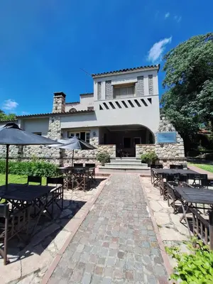 a patio with tables and umbrellas in front of a building at Posada Del Angel in Villa Serranita