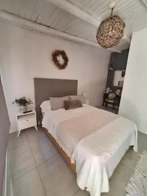 a bedroom with a large bed and a wreath on the wall at Posada Del Angel in Villa Serranita