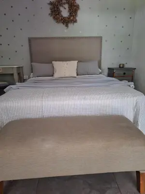 a bedroom with a large bed with white sheets at Posada Del Angel in Villa Serranita
