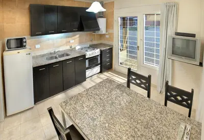 a kitchen with a white refrigerator and a table with chairs at Campiranas in Los Reartes