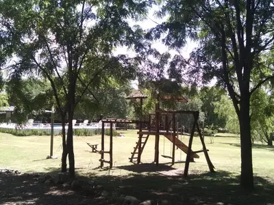 a swing set in a park with trees at Campiranas in Los Reartes