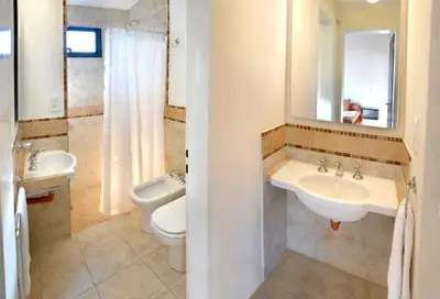 a bathroom with two sinks and a toilet and a mirror at Campiranas in Los Reartes