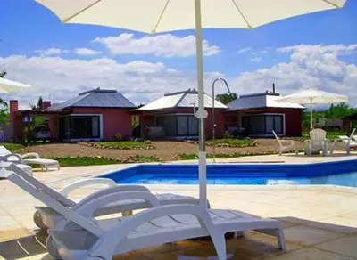 a pair of chairs and an umbrella next to a pool at Campiranas in Los Reartes