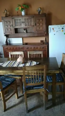 a kitchen with a wooden table and a refrigerator at La Casita de Sil in Mina Clavero