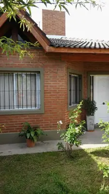 a brick house with two windows and a door at La Casita de Sil in Mina Clavero