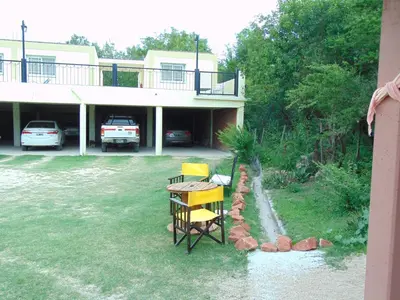 a house with a table and chairs in the yard at Hosteria Aguas Claras in Mina Clavero