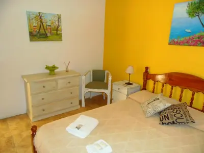 a bedroom with a bed and a dresser and a chair at Hosteria Aguas Claras in Mina Clavero