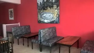 two chairs and a table and a painting on a wall at Hosteria Aguas Claras in Mina Clavero