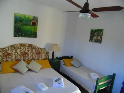 a room with two beds and a ceiling fan at Hosteria Aguas Claras in Mina Clavero