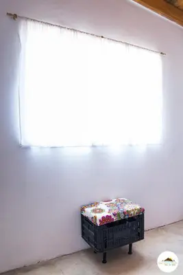 a room with a white wall with a window and a bench at Entre Sierras y Pajaros in Las Rabonas