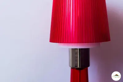 a red lamp with a red shade on top of it at Entre Sierras y Pajaros in Las Rabonas