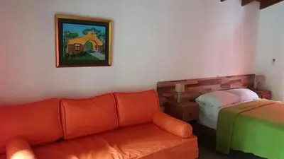 a living room with a couch and a bed at Cabañas Villa Bonita in Villa Ciudad Parque