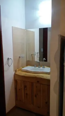 a bathroom with a sink and a large mirror at Cabañas Villa Bonita in Villa Ciudad Parque