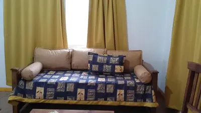 a couch sitting in a room with a bed at Cabañas Villa Bonita in Villa Ciudad Parque