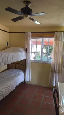 a bedroom with two bunk beds and a window at Lo de Lili Departamentos Mina Clavero in Mina Clavero