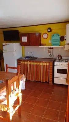 a kitchen with a table and a stove top oven at Lo de Lili Departamentos Mina Clavero in Mina Clavero