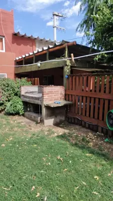 a bench sitting in the grass next to a building at Lo de Lili Departamentos Mina Clavero in Mina Clavero