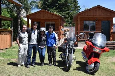 a group of people standing next to a motorcycle at Cabañas 57 in Villa Carlos Paz