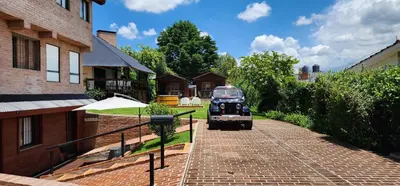 an old car is driving down a brick driveway at Cabañas 57 in Villa Carlos Paz