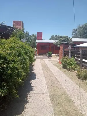 a walkway in front of a red building at Cabañas mi Sueño in Villa Carlos Paz