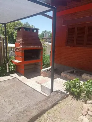 an outdoor brick oven sitting next to a house at Cabañas mi Sueño in Villa Carlos Paz