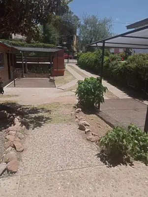 a sidewalk with two bushes and a bus stop at Cabañas mi Sueño in Villa Carlos Paz