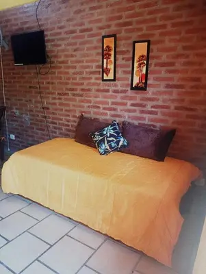 a bed in a room with a brick wall at Cabañas mi Sueño in Villa Carlos Paz