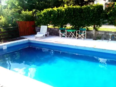 two chairs and a table next to a swimming pool at Cabañas mi Sueño in Villa Carlos Paz