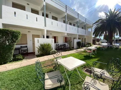 a patio with chairs and tables in front of a building at Hotel Los Aromos in Mina Clavero
