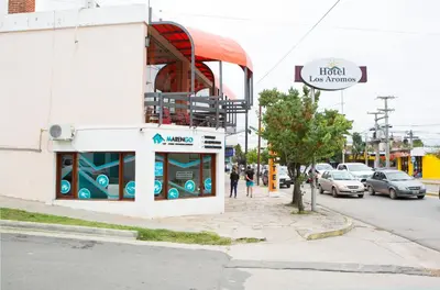 a building on the corner of a street with cars at Hotel Los Aromos in Mina Clavero