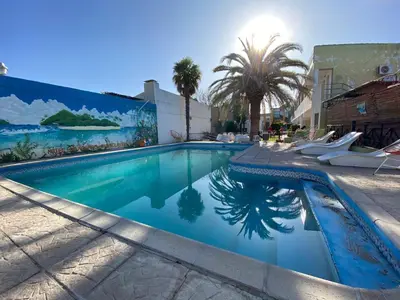 a swimming pool with blue water in front of a building at Hotel Los Aromos in Mina Clavero
