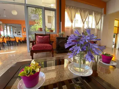 a living room with purple flowers in a vase on a table at Hotel Los Aromos in Mina Clavero