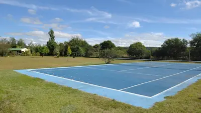 a tennis court in the middle of a field at El Caserio Casas de Campo in Villa Cura Brochero