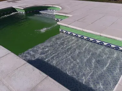 a pool of water next to a walkway next to a body of water at Apart y Suite Portal del Luz in Mina Clavero