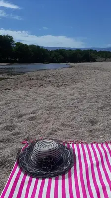 a pink and white striped umbrella on the beach at Apart y Suite Portal del Luz in Mina Clavero