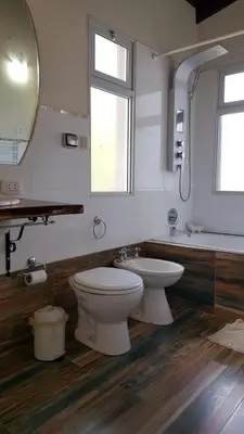 a bathroom with a toilet and a sink and a mirror at Apart y Suite Portal del Luz in Mina Clavero