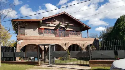 a building with a fence in front of it at Apart y Suite Portal del Luz in Mina Clavero