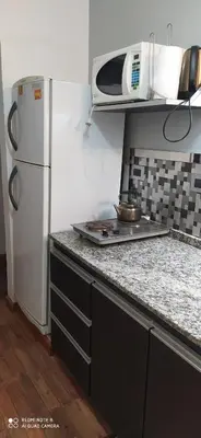 a kitchen with a white refrigerator and a microwave at Apart y Suite Portal del Luz in Mina Clavero