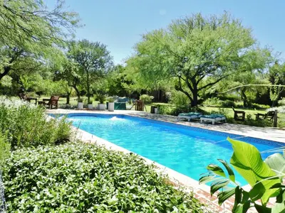a swimming pool in a yard with trees at Posada Terracota in Nono