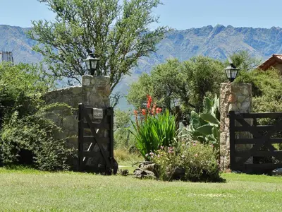 a gate to a garden with mountains in the background at Posada Terracota in Nono