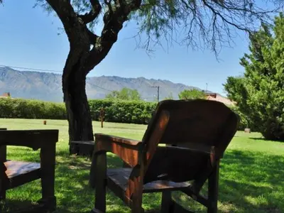 a wooden bench sitting under a tree in a field at Posada Terracota in Nono